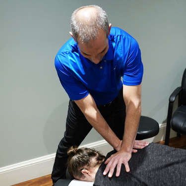 patient laying face down on chiropractic table receiving and adjustment